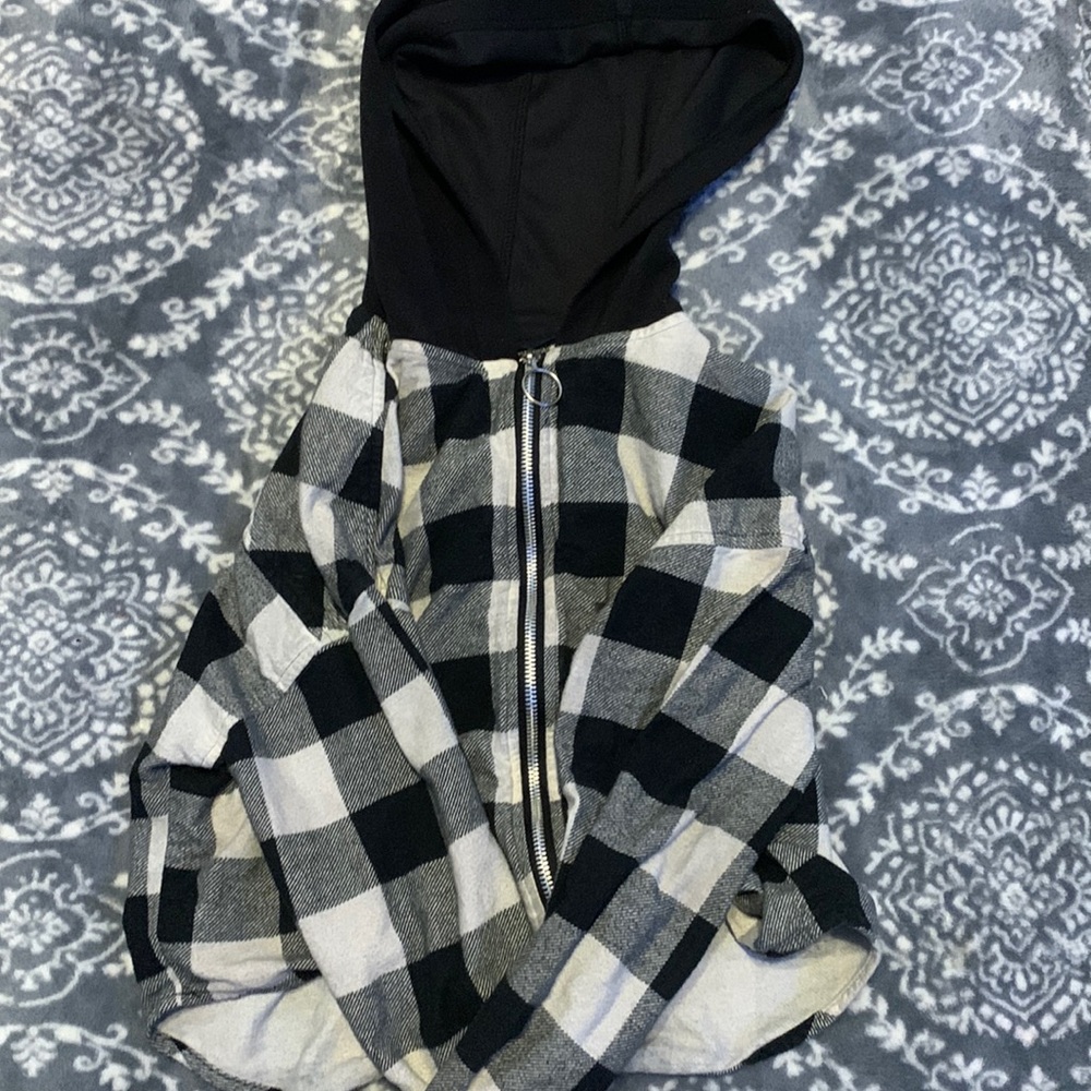 A zip up jacket that is black, gray, and white